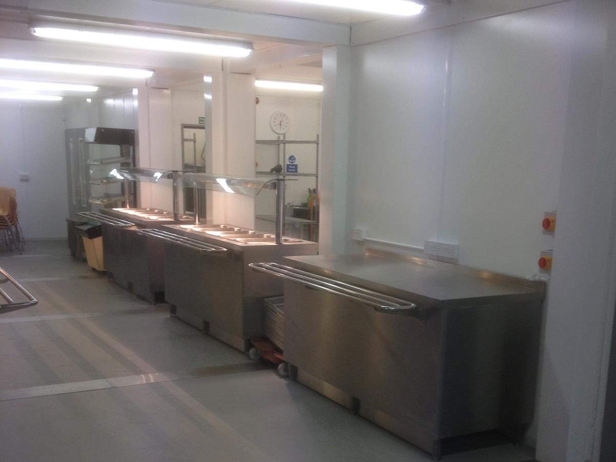 Large servery area adjoining the kitchen area of a refectory.
